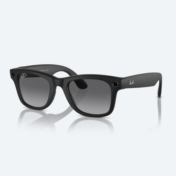 solid black traditional style Ray Ban sunglasses with small camera-like lenses in the two upper corners of the frame of the sunglasses. Solid white background.
